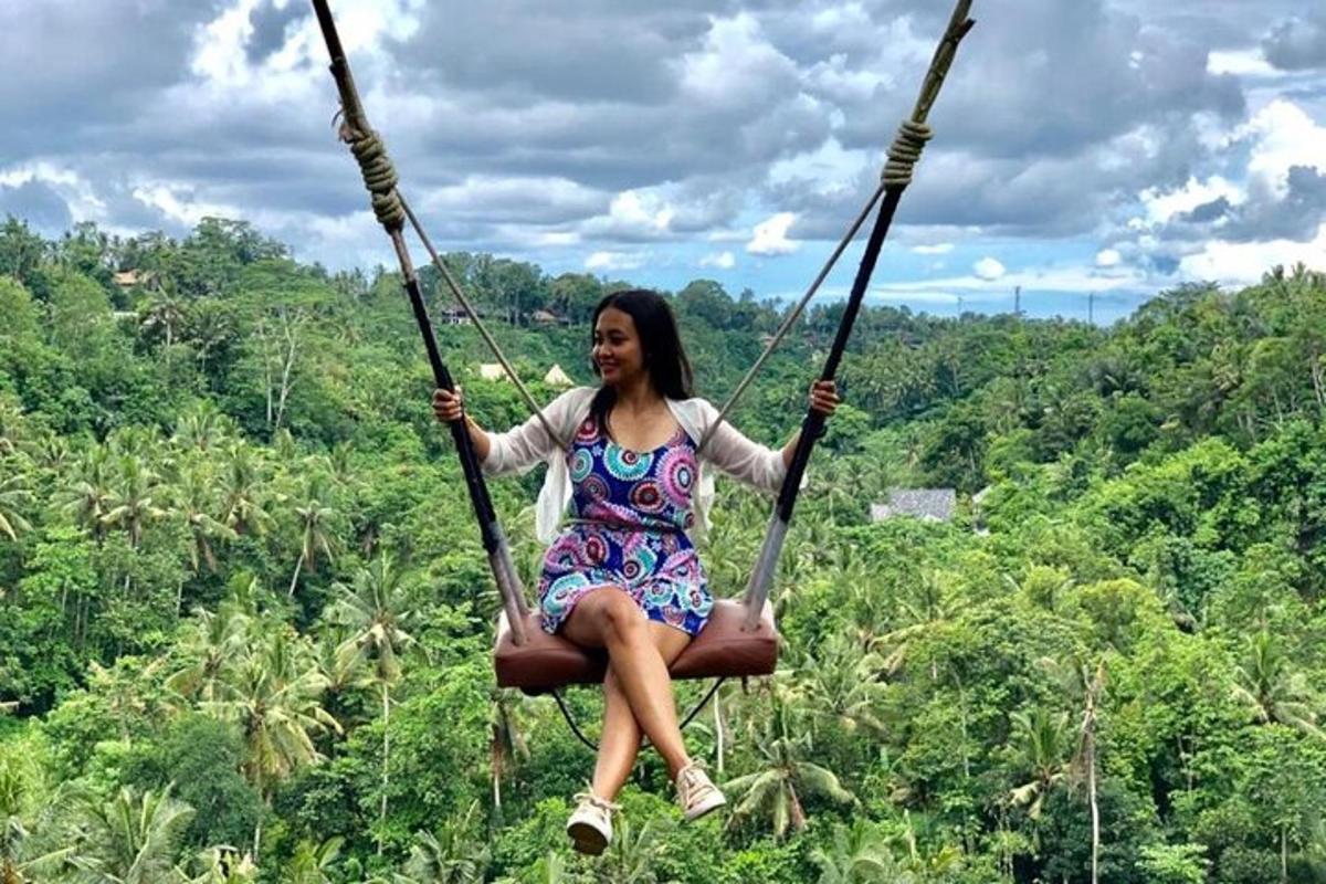 seorang wanita duduk di atas buaian di dalam hutan