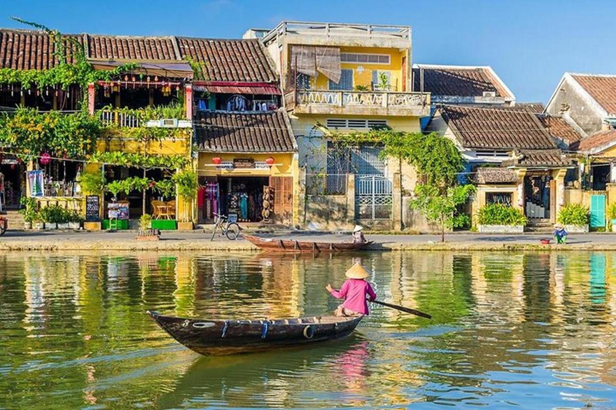 a person in a boat on a river with buildings