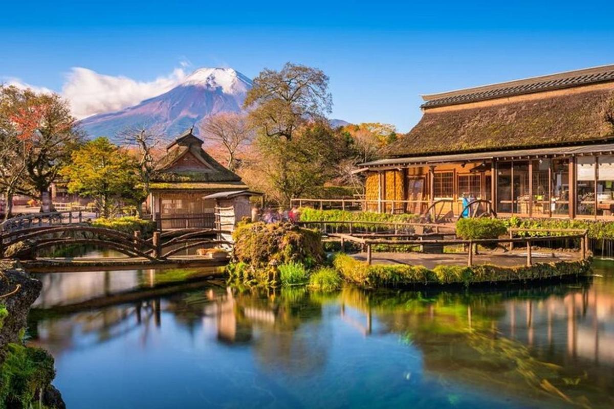 Un edificio con un puente sobre un río con una montaña.