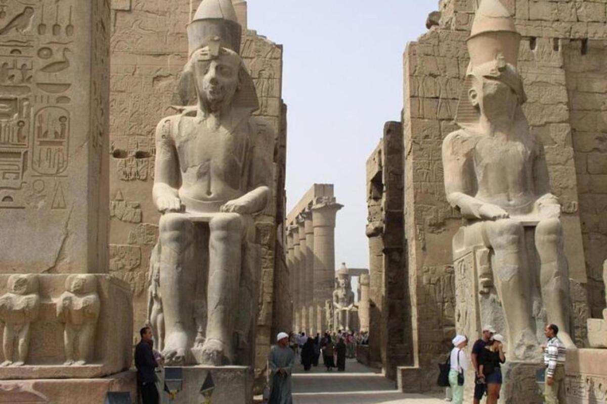 cilvēku grupa, kas stāv statuju priekšā