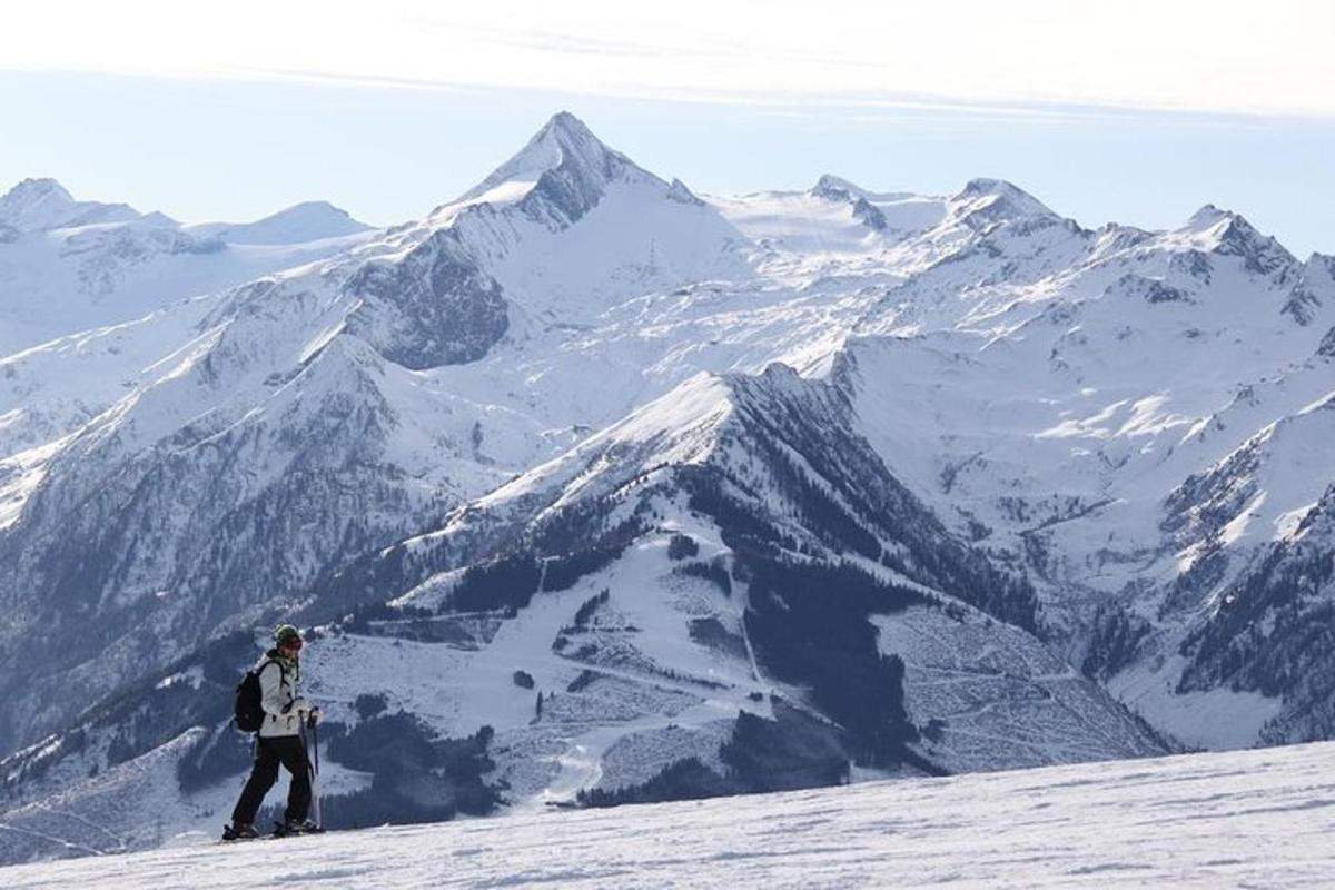 uma pessoa em pé no topo de uma montanha coberta de neve