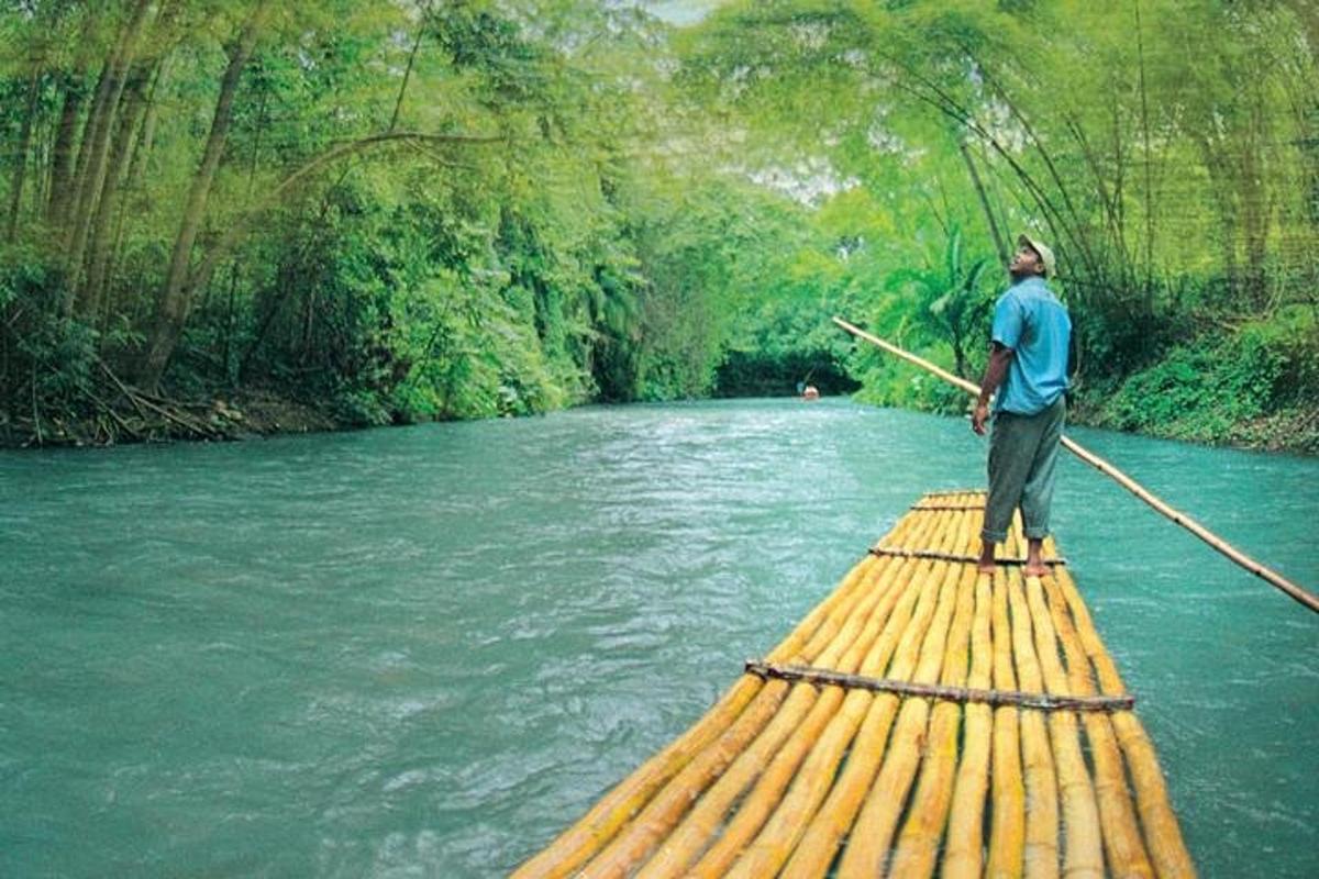 một người đàn ông đang đứng trên một chiếc bè trên sông