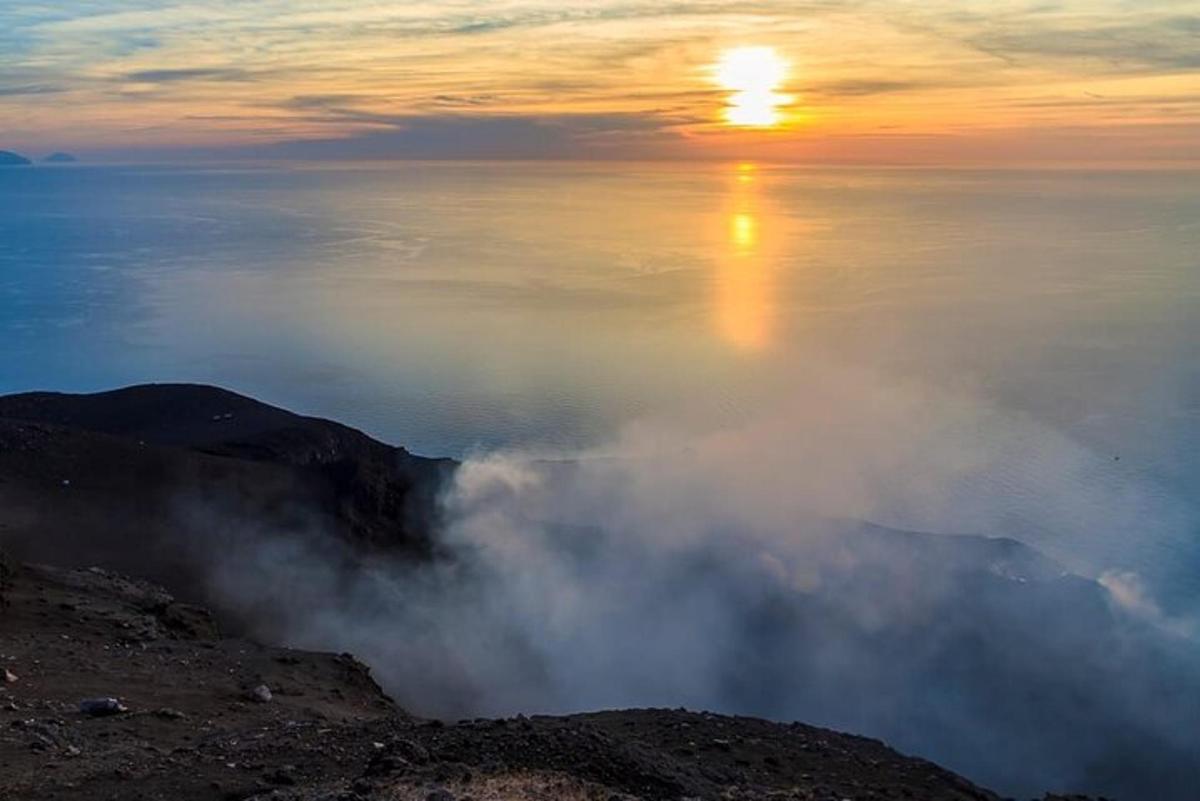 uma vista do oceano com o sol nascendo sobre as nuvens