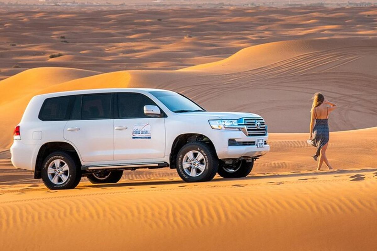 a woman walking in the desert next to a white truck