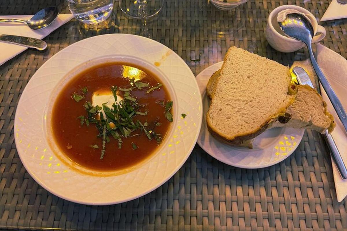 a plate of soup and a sandwich on a table