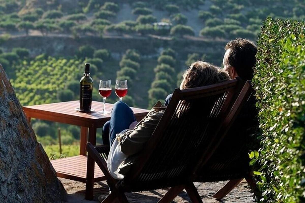 Un hombre y una mujer sentados en una mesa con copas de vino.