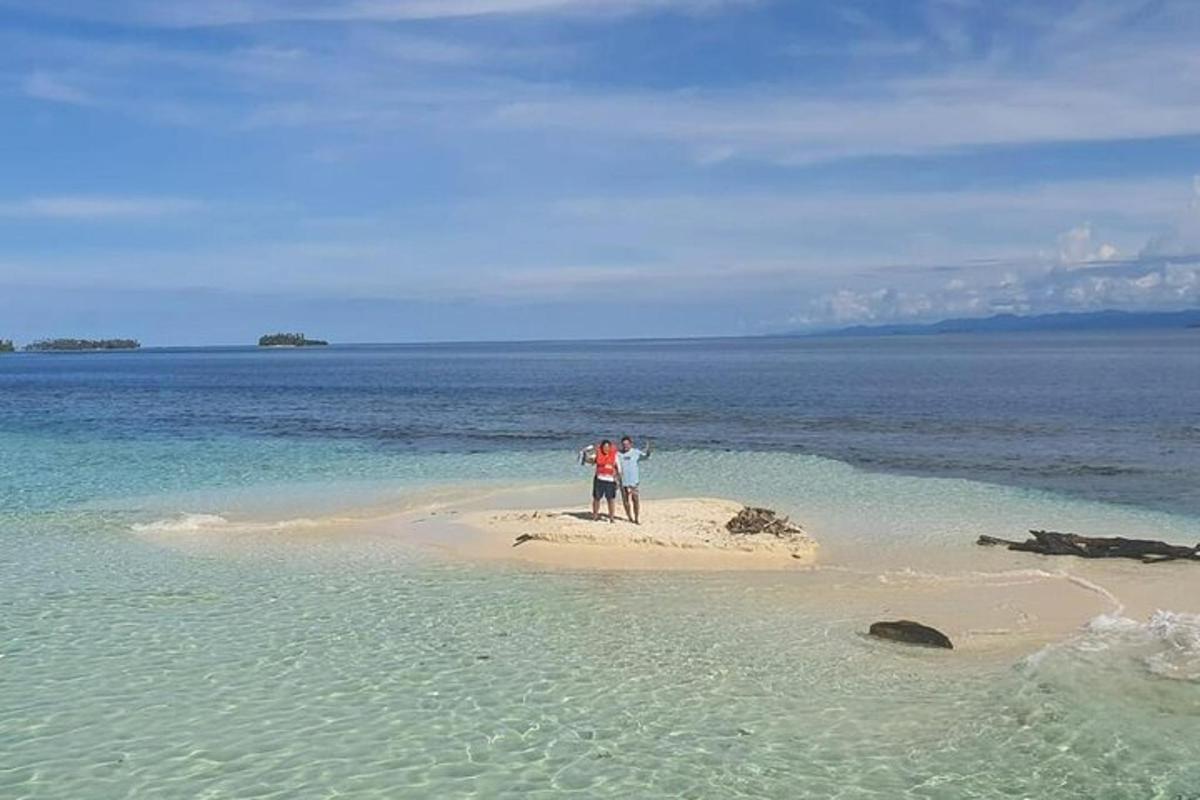due persone in piedi su una piccola isola nell'oceano