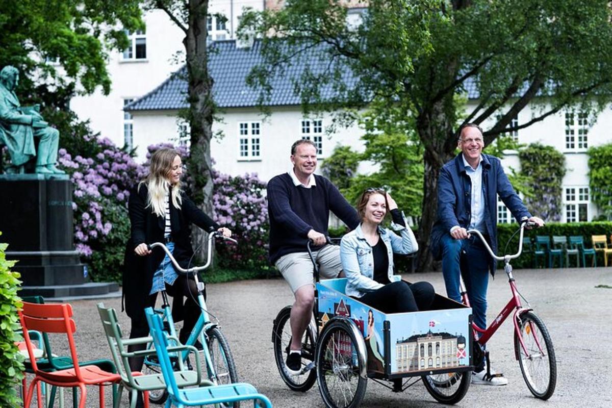 a group of people riding bikes with a cart on it