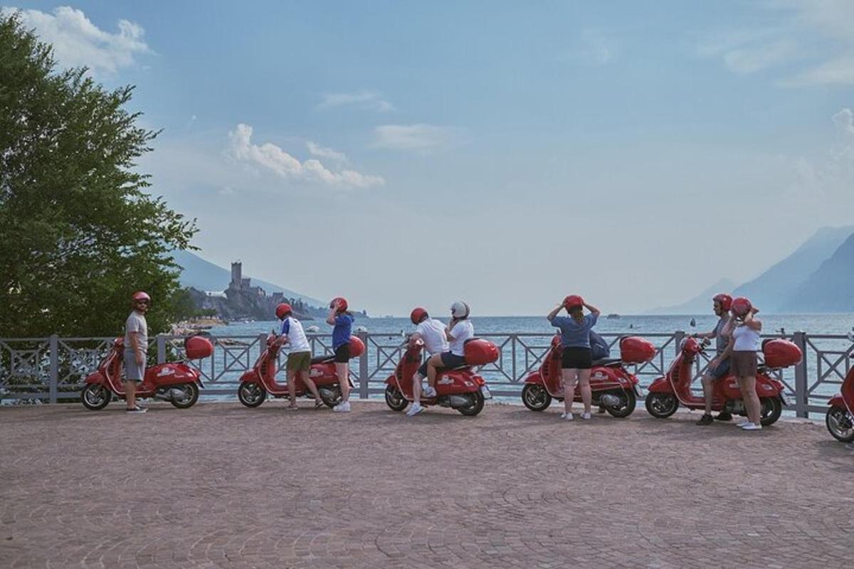 un gruppo di persone su scooter parcheggiati vicino all'acqua
