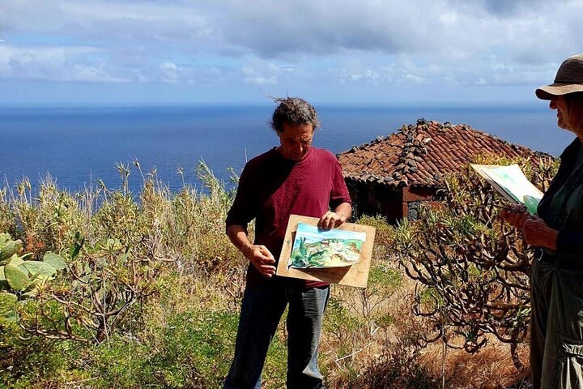 un home sosté una pintura en una caixa