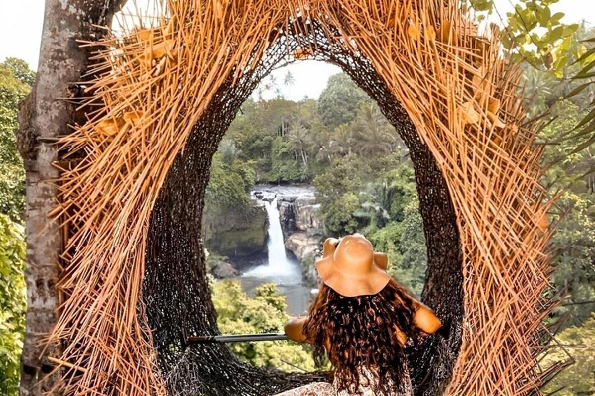 uma mulher em um arco de palha com uma cachoeira ao fundo