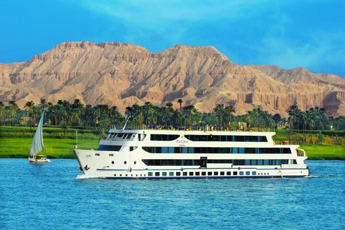a cruise ship on the water with a mountain in the background