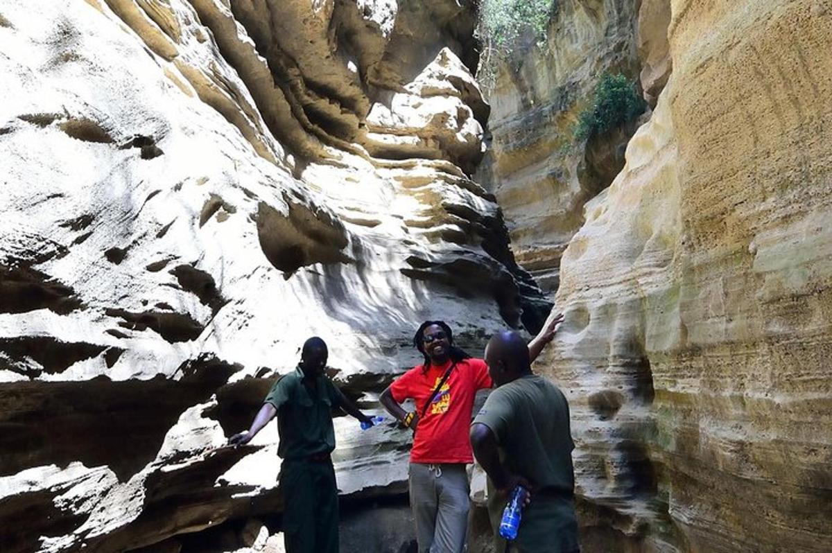 a group of three people standing in a canyon