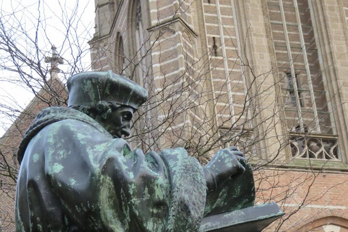 una statua di una donna seduta davanti a un edificio