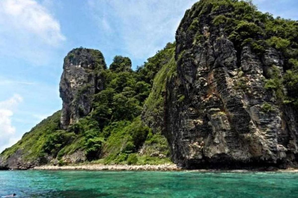 เกาะหินขนาดใหญ่ในมหาสมุทรที่มีน้ำทะเลสีฟ้า