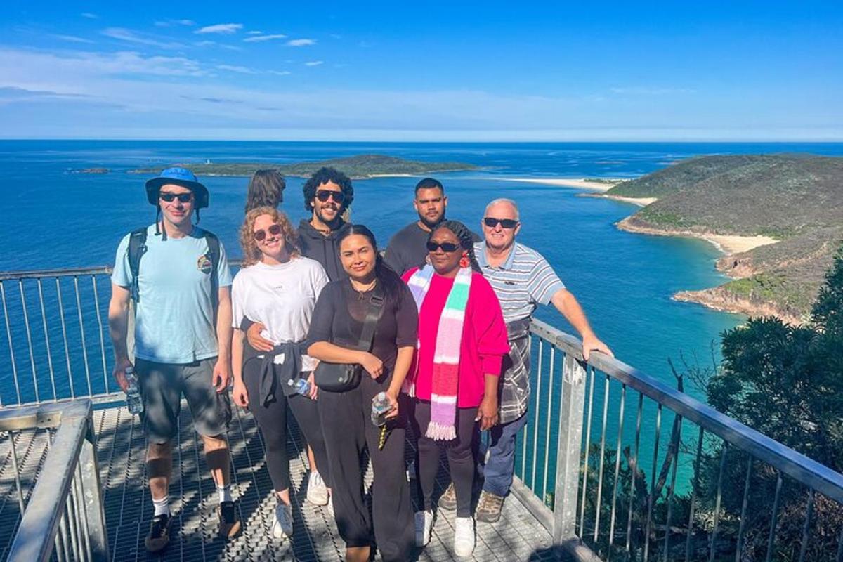 um grupo de pessoas posando para uma foto em uma passarela perto do oceano