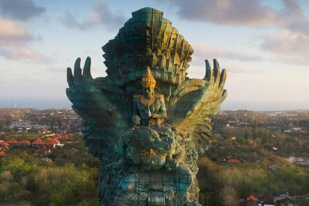 Una estatua de un pájaro con una ciudad al fondo.
