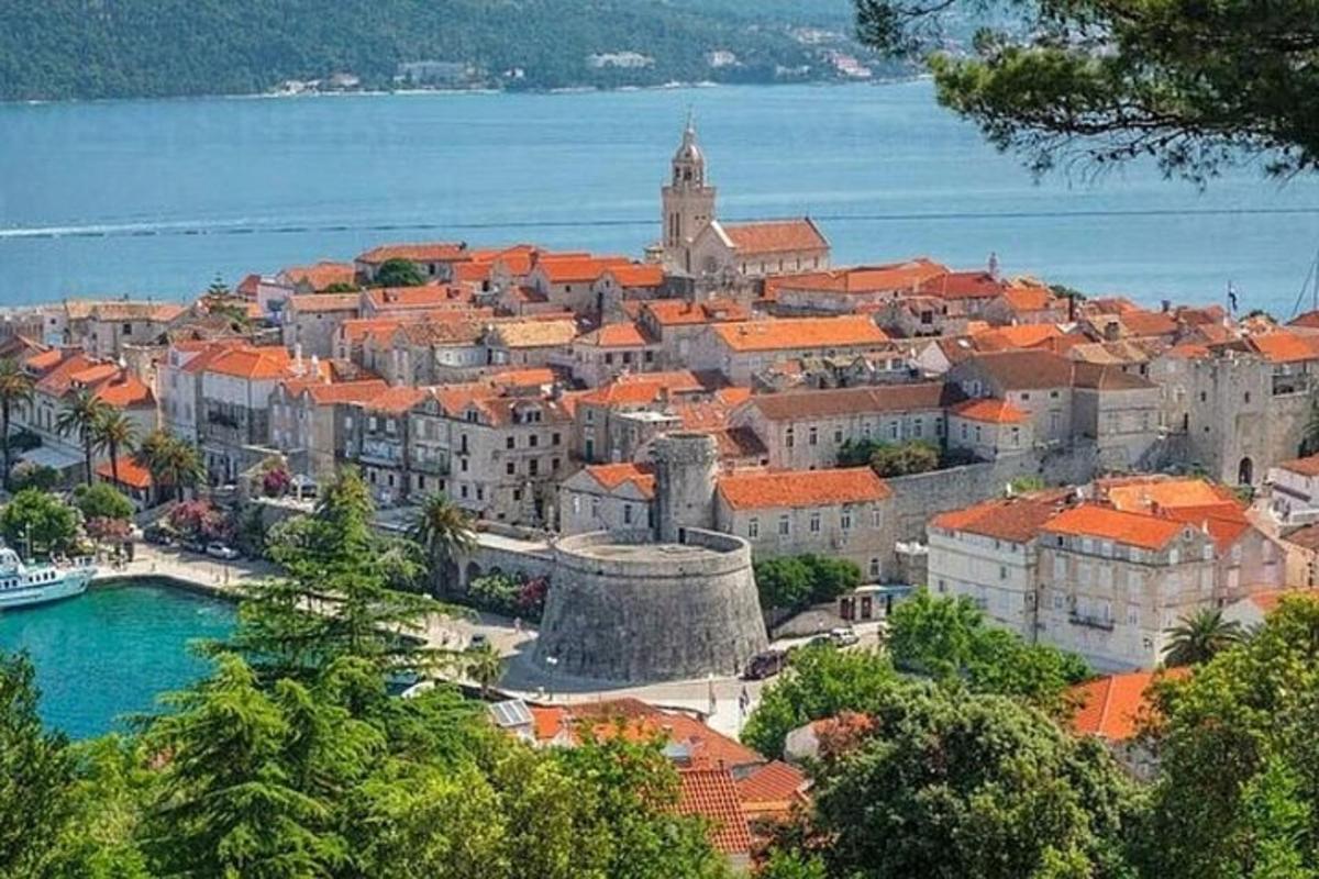 pilsēta ar oranžiem jumtiem un ūdenstilpni