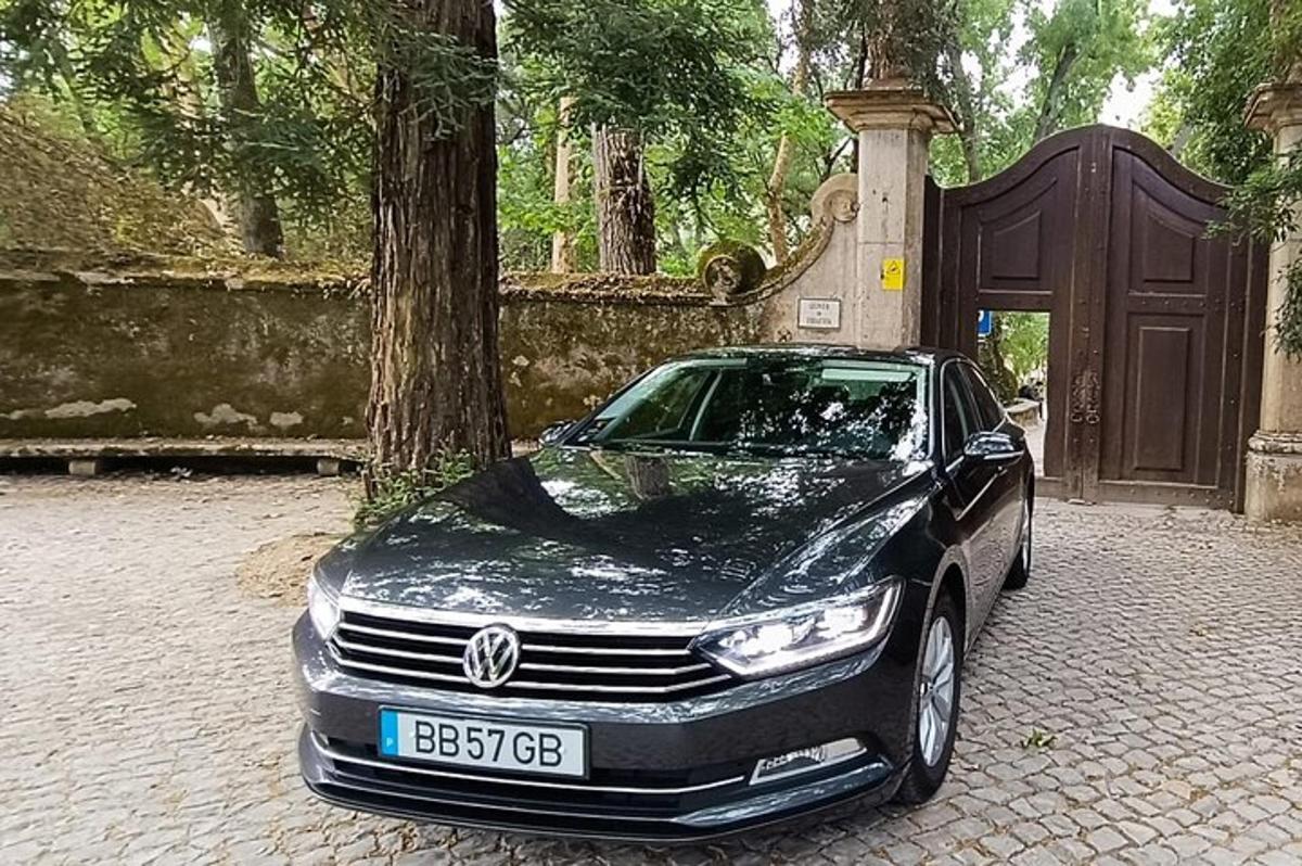 o mașină neagră parcată în fața unui copac