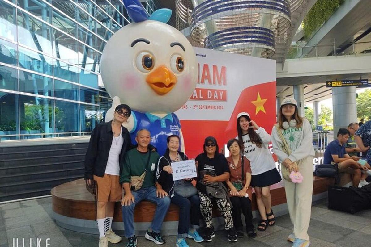 un gruppo di persone in posa per una foto davanti a un palloncino a forma di pollo