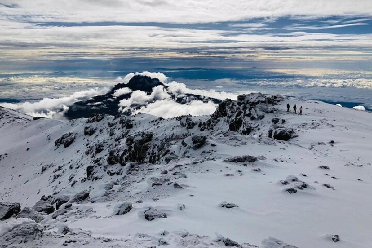 a mountain covered in snow with people standing on it
