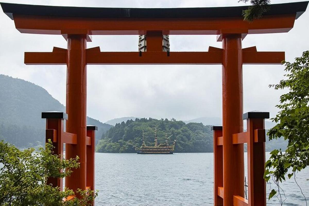 un cancello torii arancione con una barca in acqua