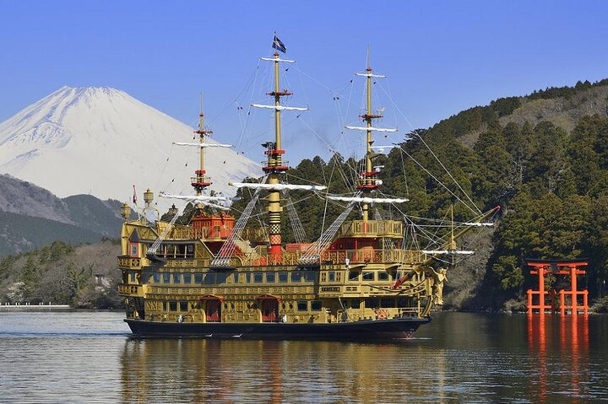 a large boat in the water with a mountain in the background