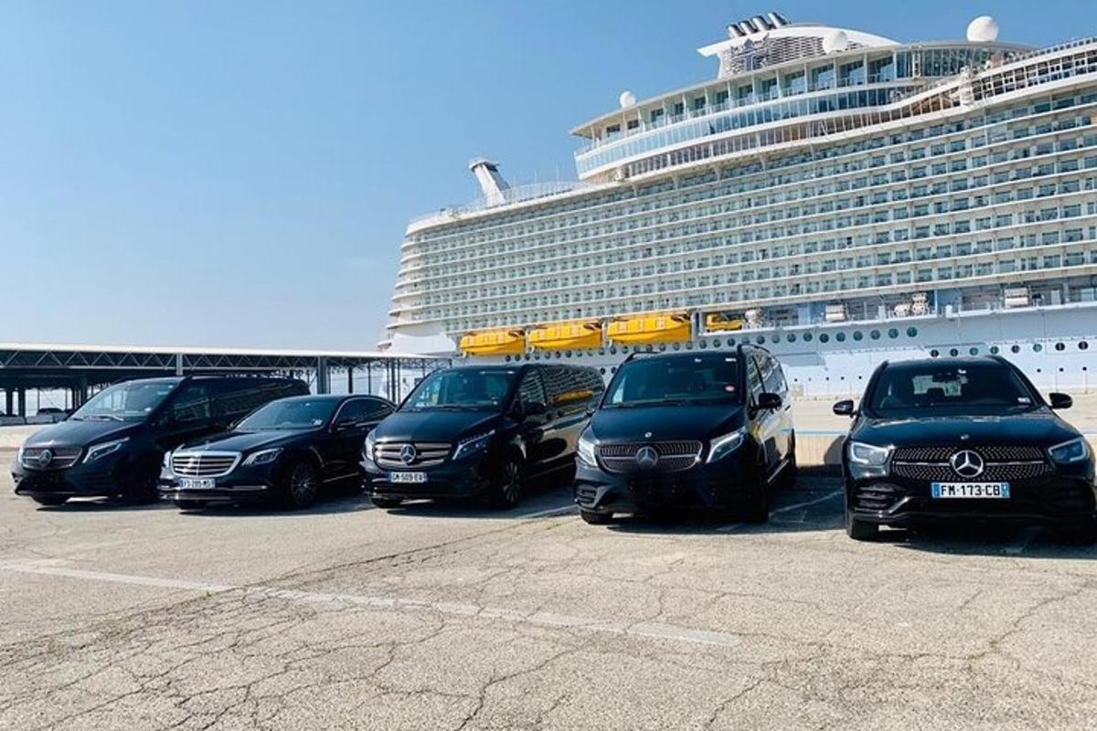 una fila di auto parcheggiate in un parcheggio accanto a una nave da crociera