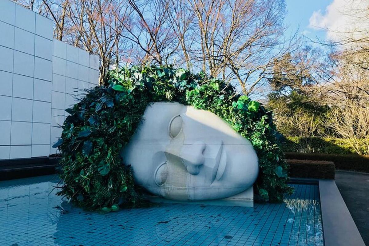 o vază albă mare, acoperită cu plante verzi