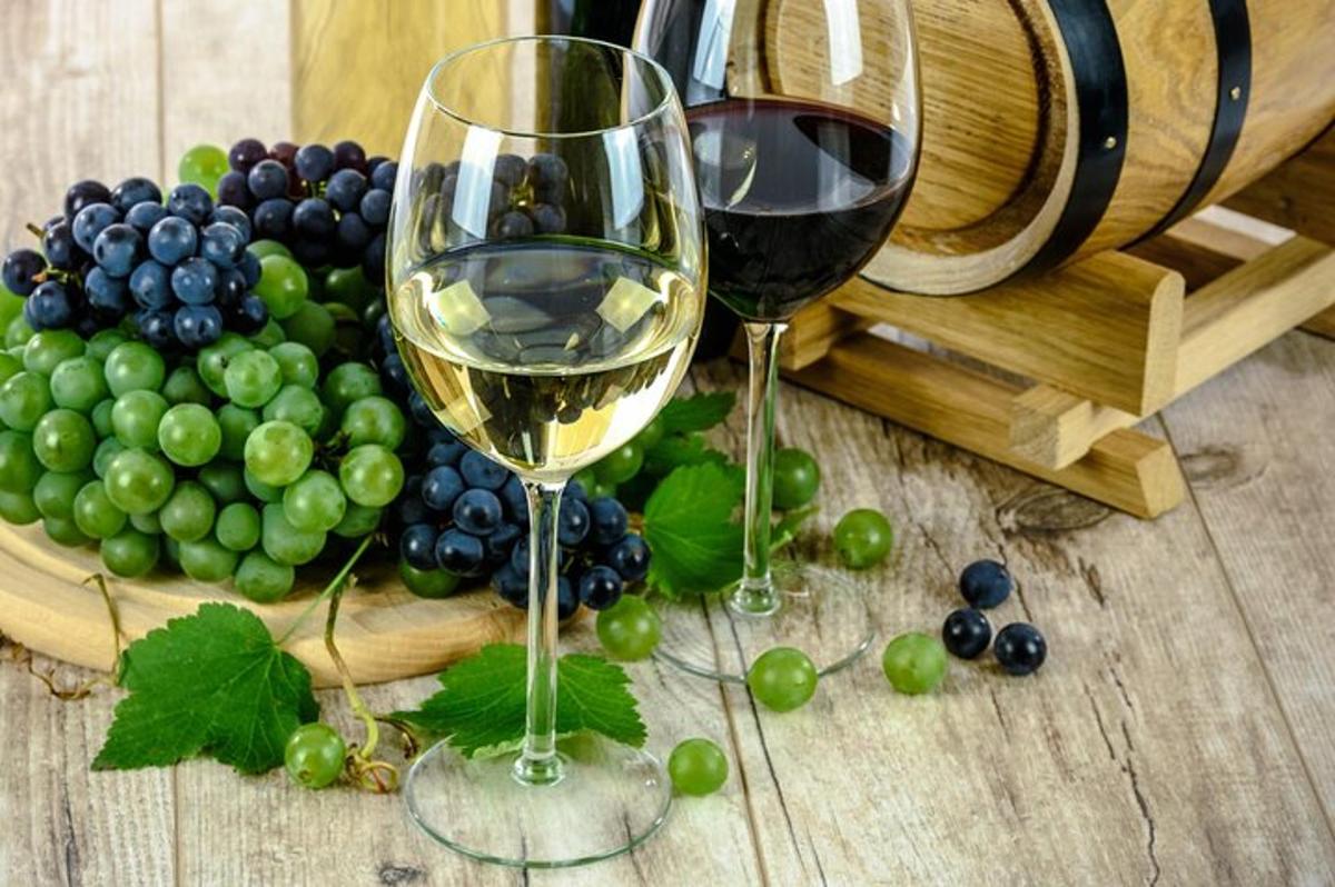 due bicchieri di vino accanto a un grappolo d'uva