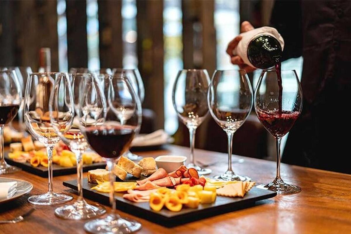 una persona che versa il vino nei bicchieri da vino su un tavolo