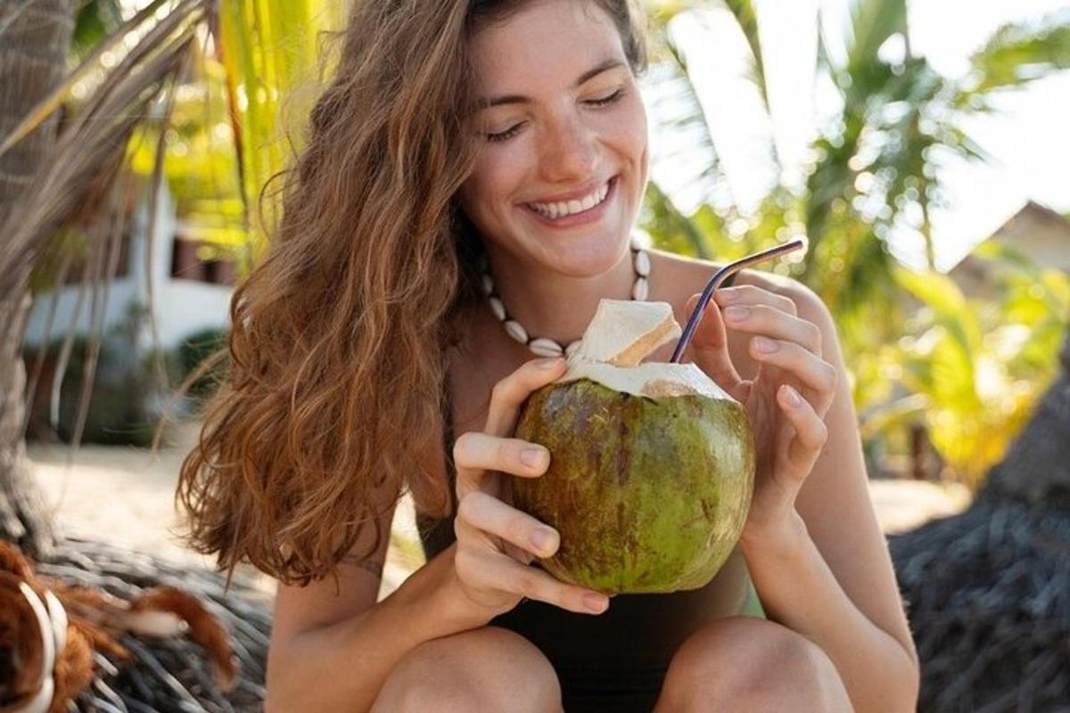 Una mujer sentada en una hamaca sosteniendo un coco.