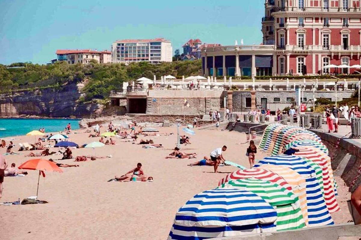 egy csoport ember a strandon napernyőkkel