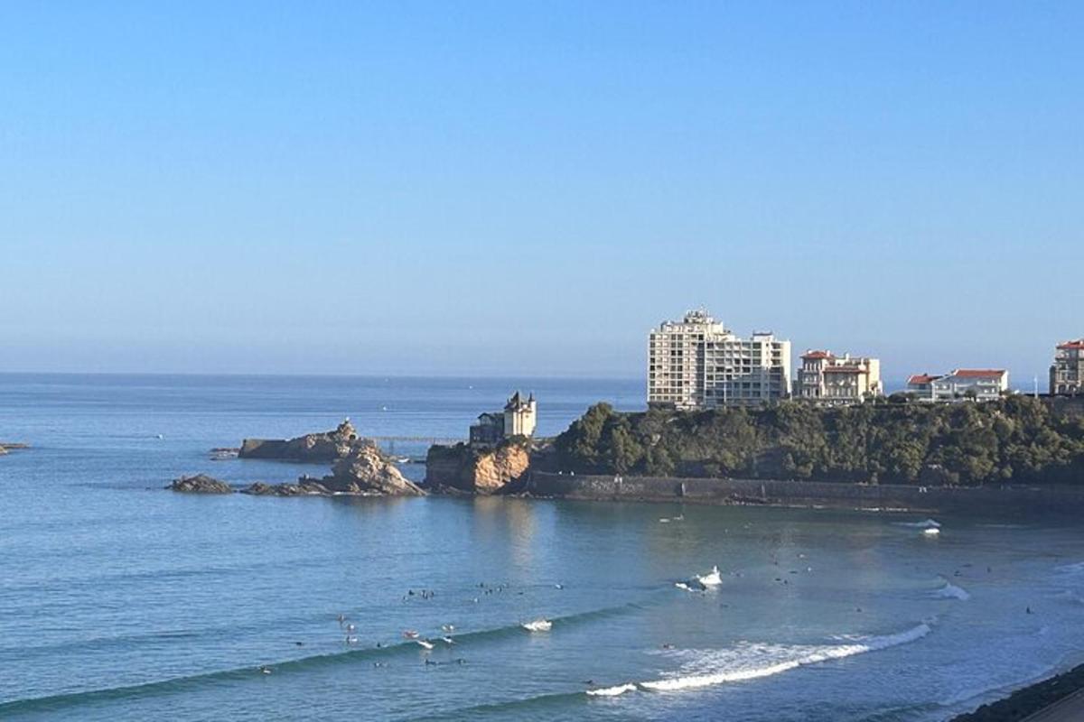 egy strand, ahol emberek szörföznek a vízben