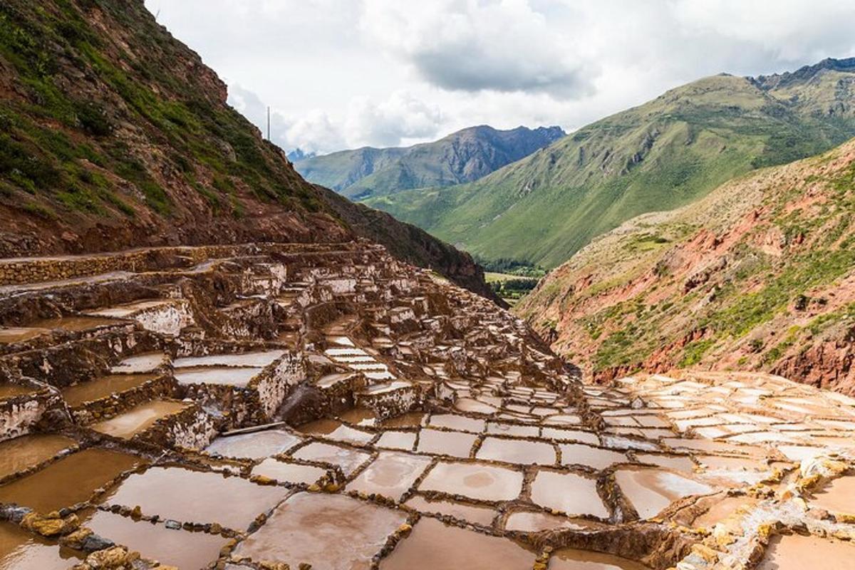 uma ruína antiga em uma montanha com montanhas ao fundo