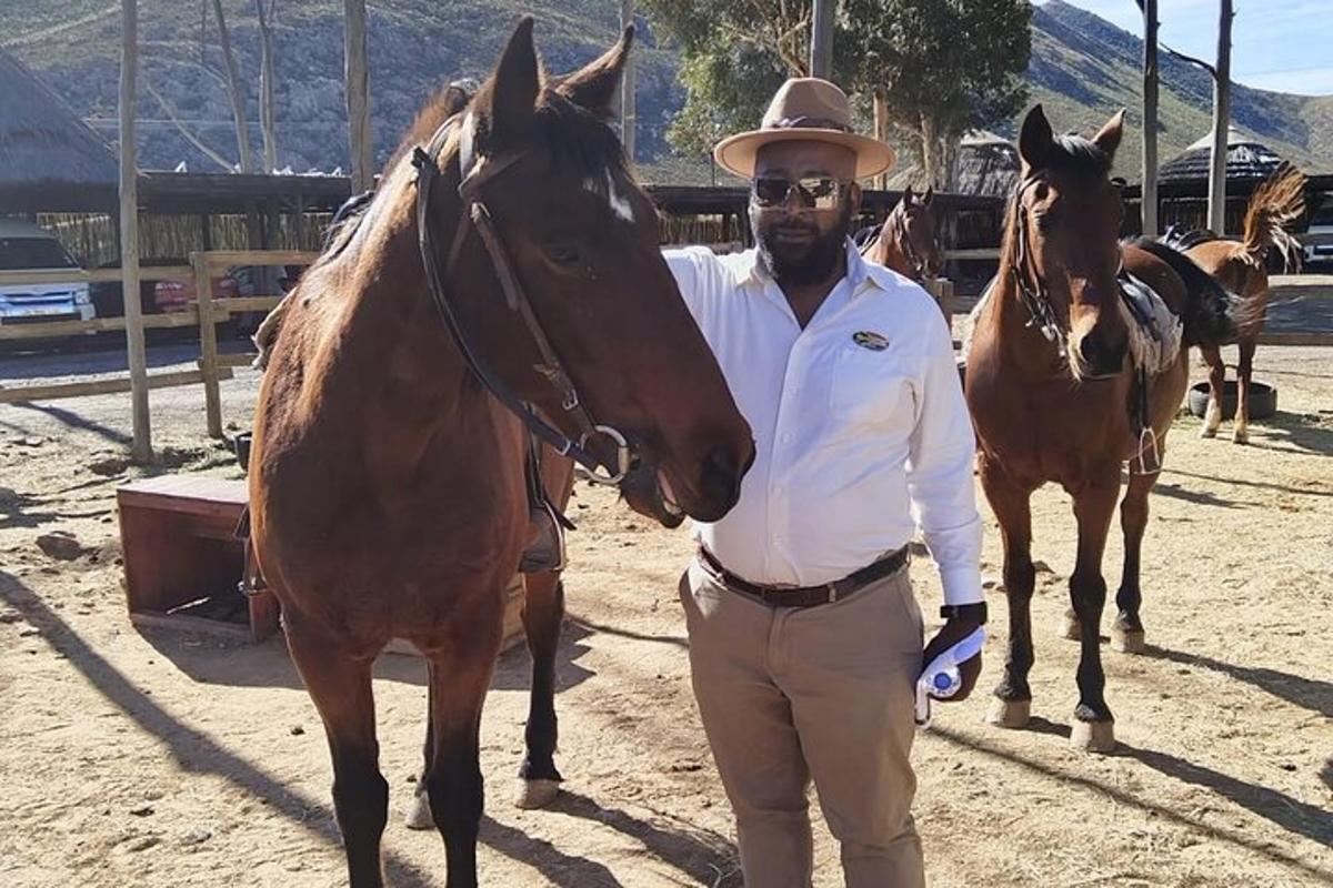 een man met een cowboyhoed die naast een paard staat