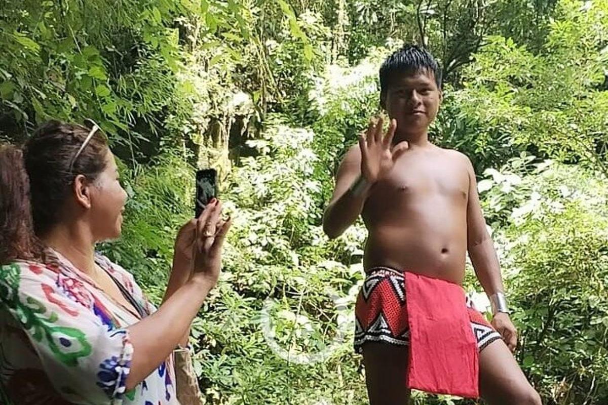 una donna che scatta una foto a un uomo nella foresta