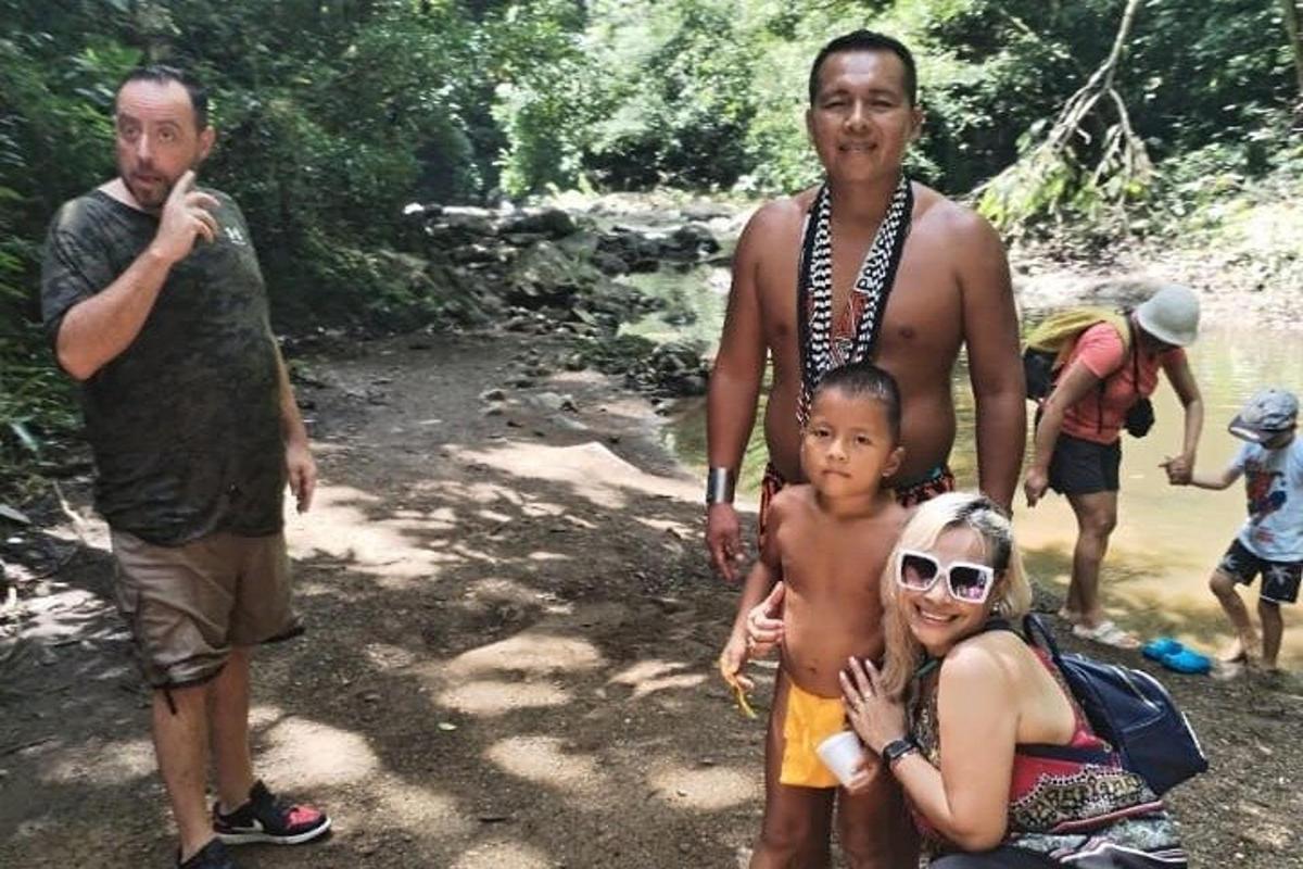seorang lelaki dan seorang wanita dan seorang kanak-kanak berdiri di sebelah sungai