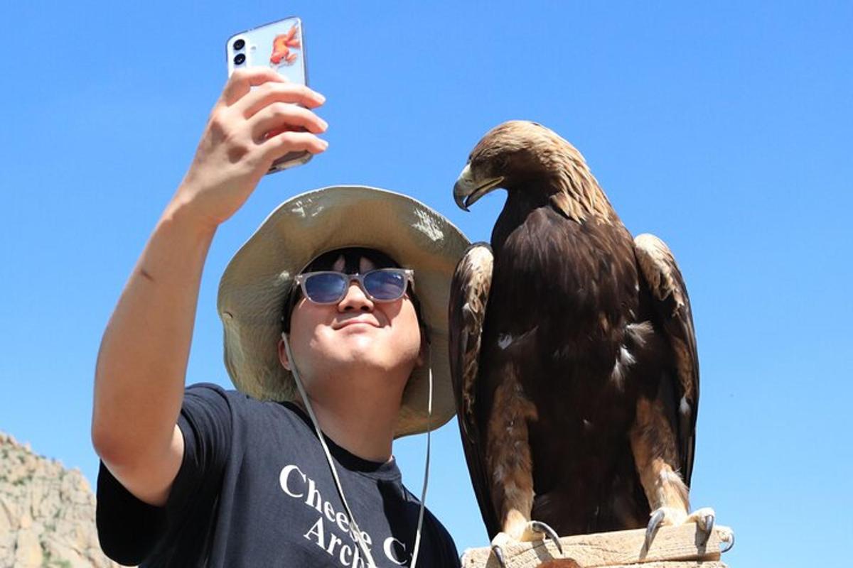 a man taking a picture of a statue of an eagle