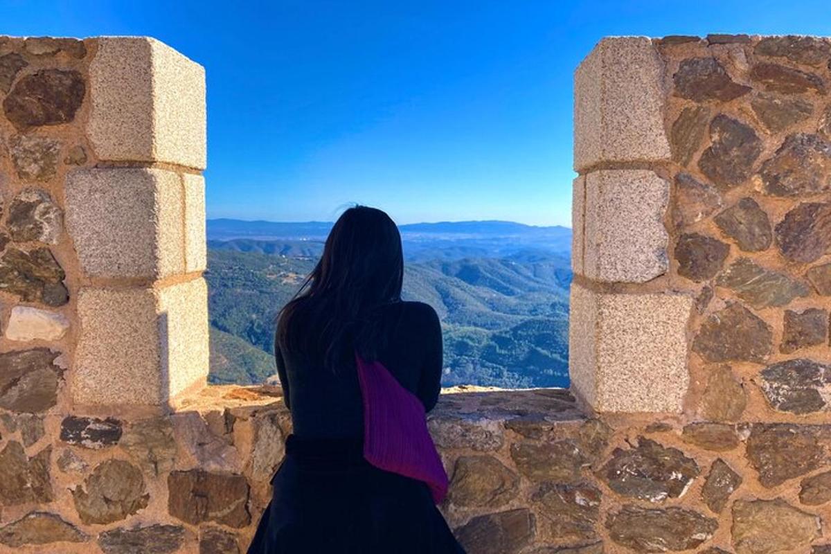 Una mujer sentada en una cornisa mirando por una ventana.