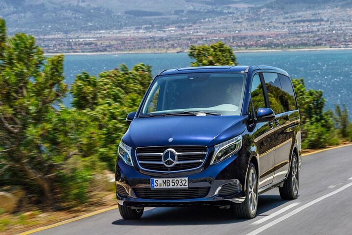 Un coche Mercedes Benz azul circulando por una carretera