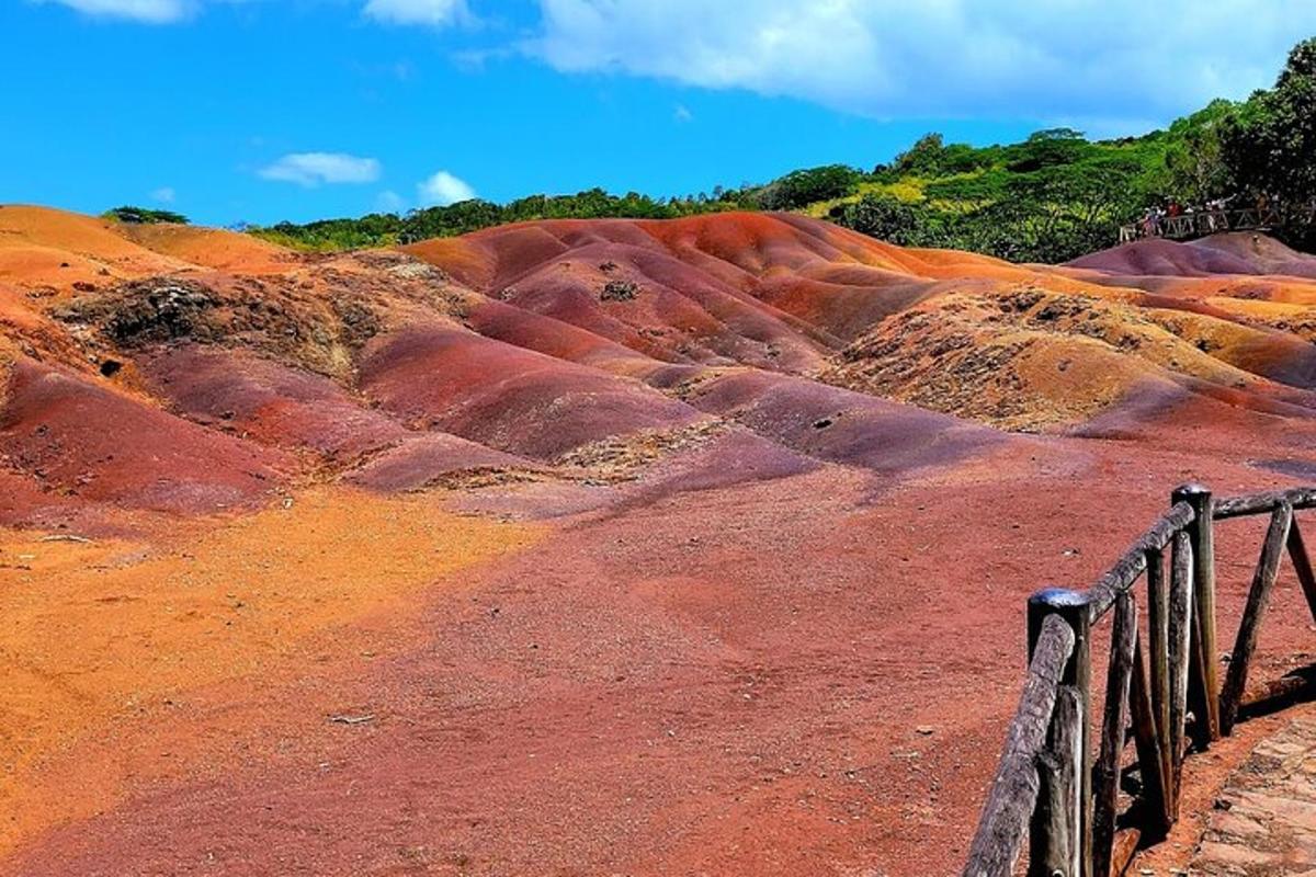 a red dirt hill with a fence on it