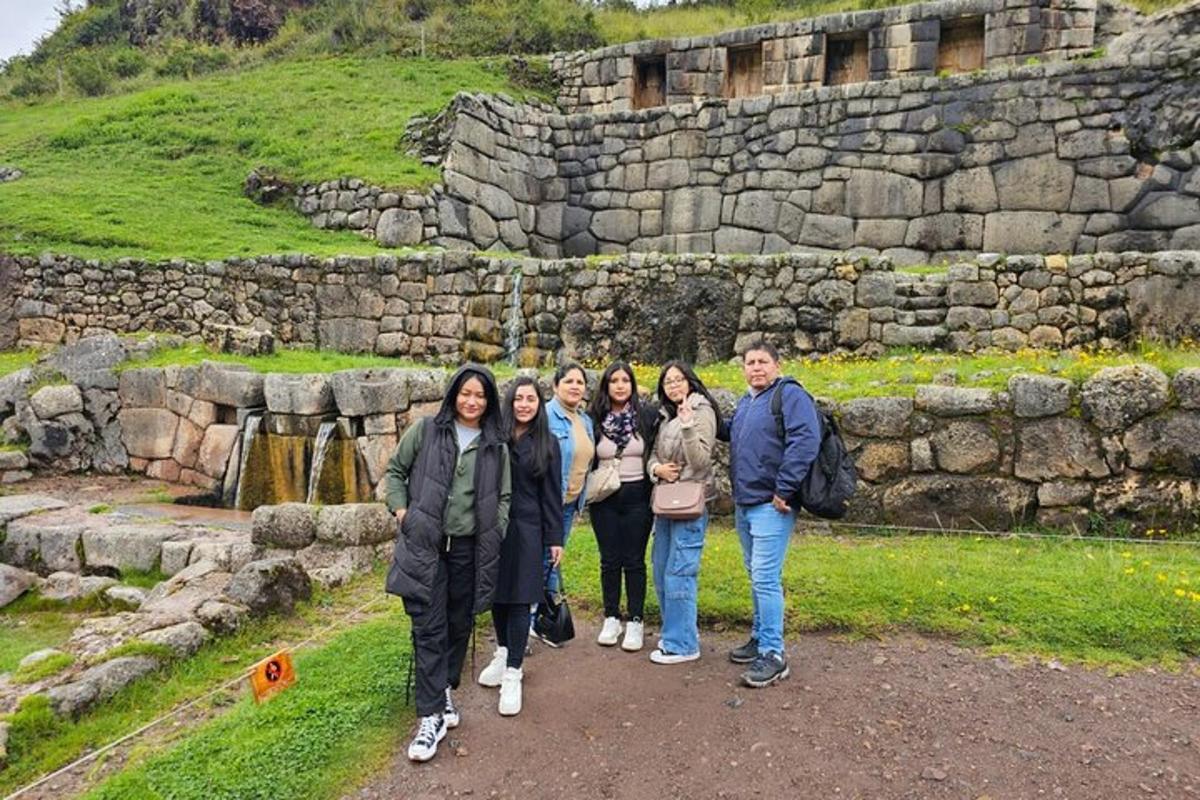 un grup de persones dretes davant d'un mur de pedra