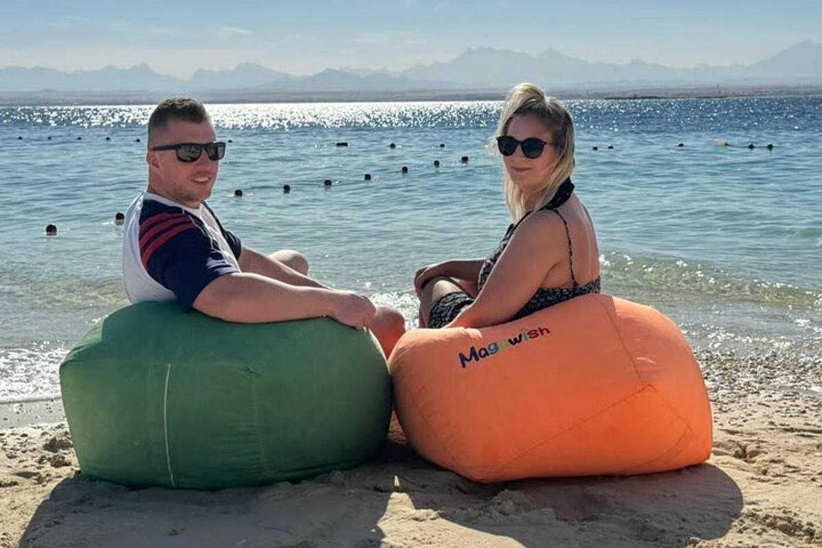 muž a žena sedia na nafukovacích atrakciách na pláži