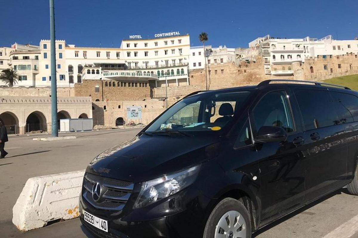 egy fekete autó parkolt egy épület előtti parkolóban