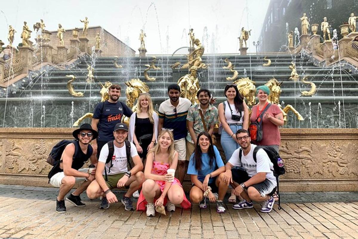 um grupo de pessoas posando para uma foto em frente a uma fonte
