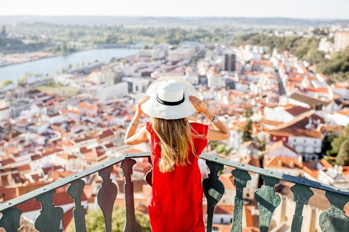 una donna con un cappello in piedi su un balcone che guarda una città