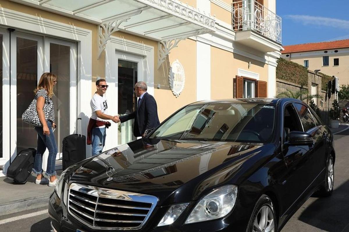 μια ομάδα ανθρώπων που στέκονται δίπλα σε ένα μαύρο αυτοκίνητο