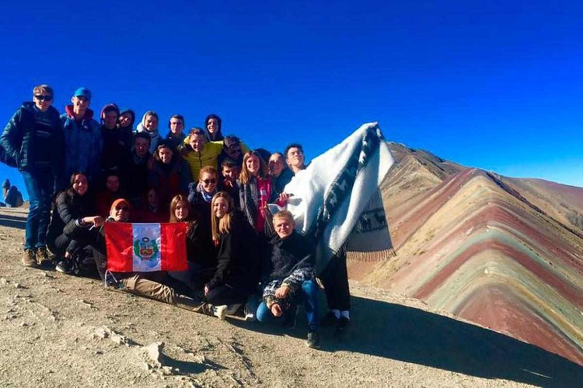 um grupo de pessoas posando em frente a uma montanha