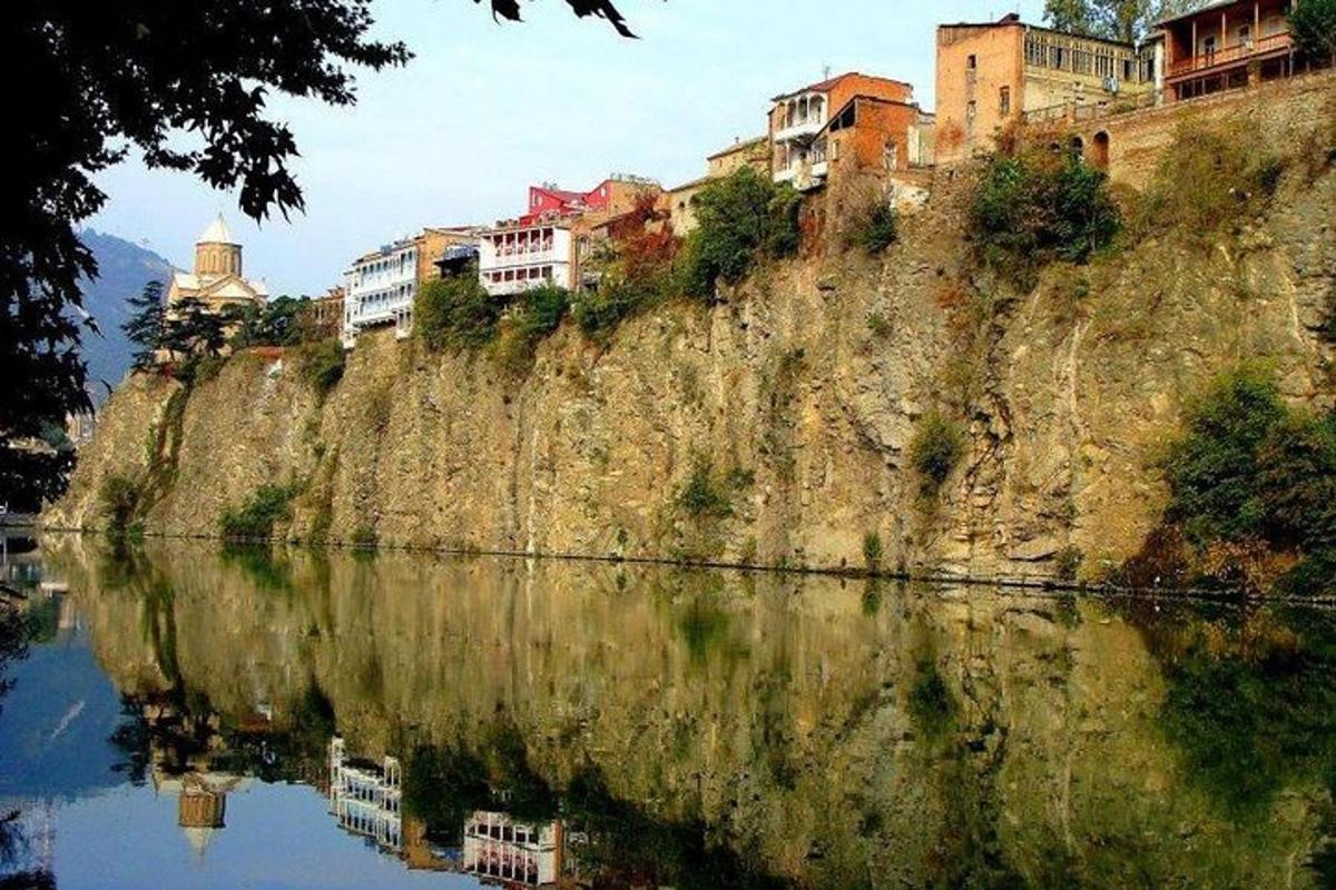 una collina con case su di essa accanto a uno specchio d'acqua